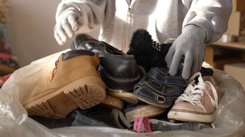 Hands sorting donated clothing and shoes for the Wardrobe ministry