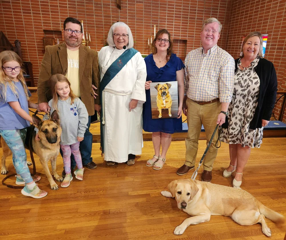 Families, clergy, two dogs, and a painted dog portrait gathered in the nave after the Blessing of the Animals
