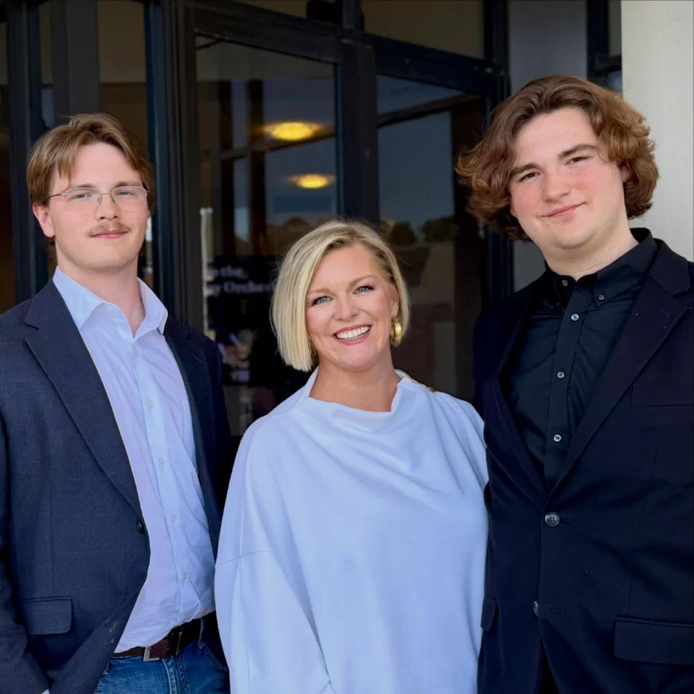 A mother and her two sons dressed up outside a concert hall