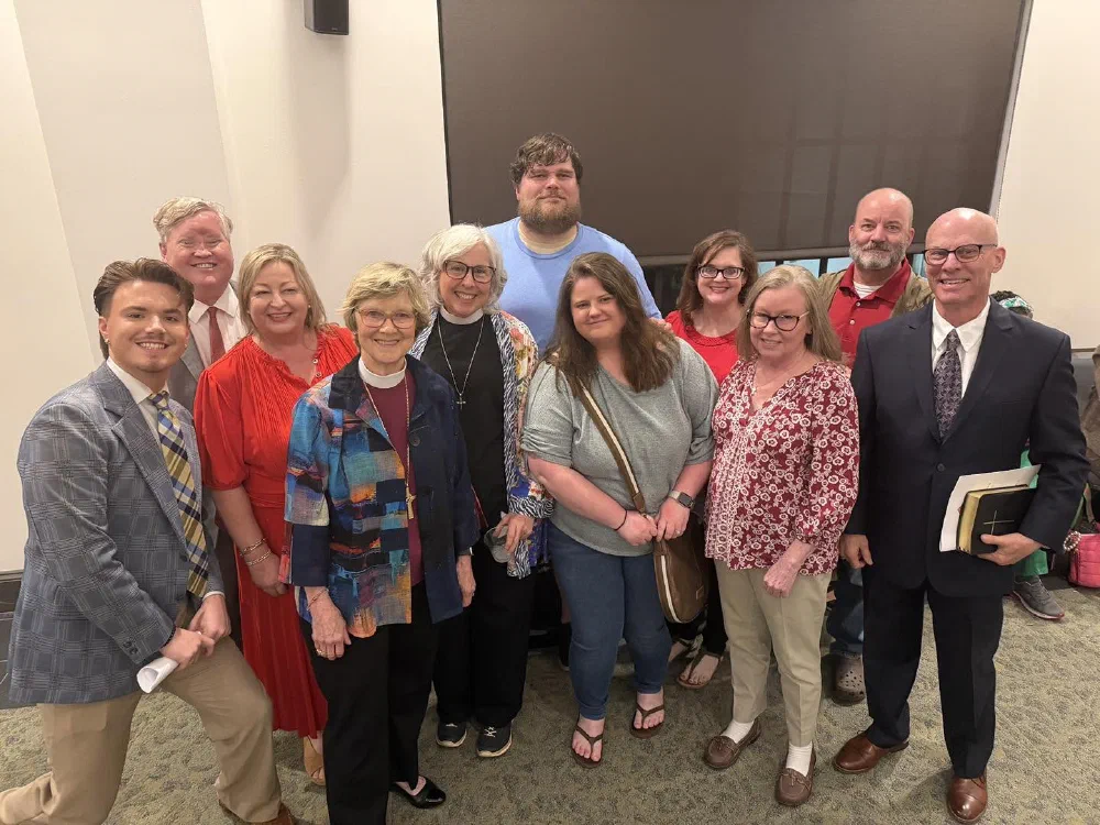 A smiling group of parishioners and clergy gathered for a group photo at a church event